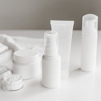 white plastic bottles and containers for skincare on a white counter