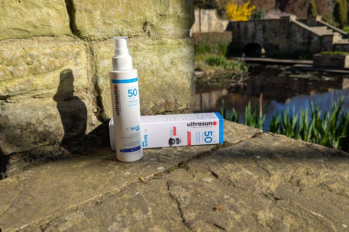 Ultrasun sport spray set on a wall  with pond in the backdrop