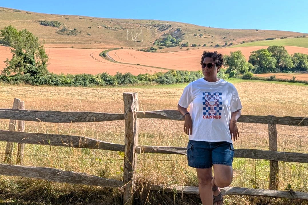 black woman leanin on fence with The Long Man of Wilmington