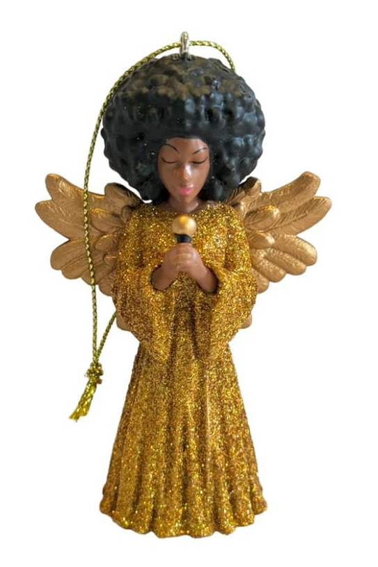 Beverley Angel by March Muses with big afro hair dressed in gold dress holding a mic