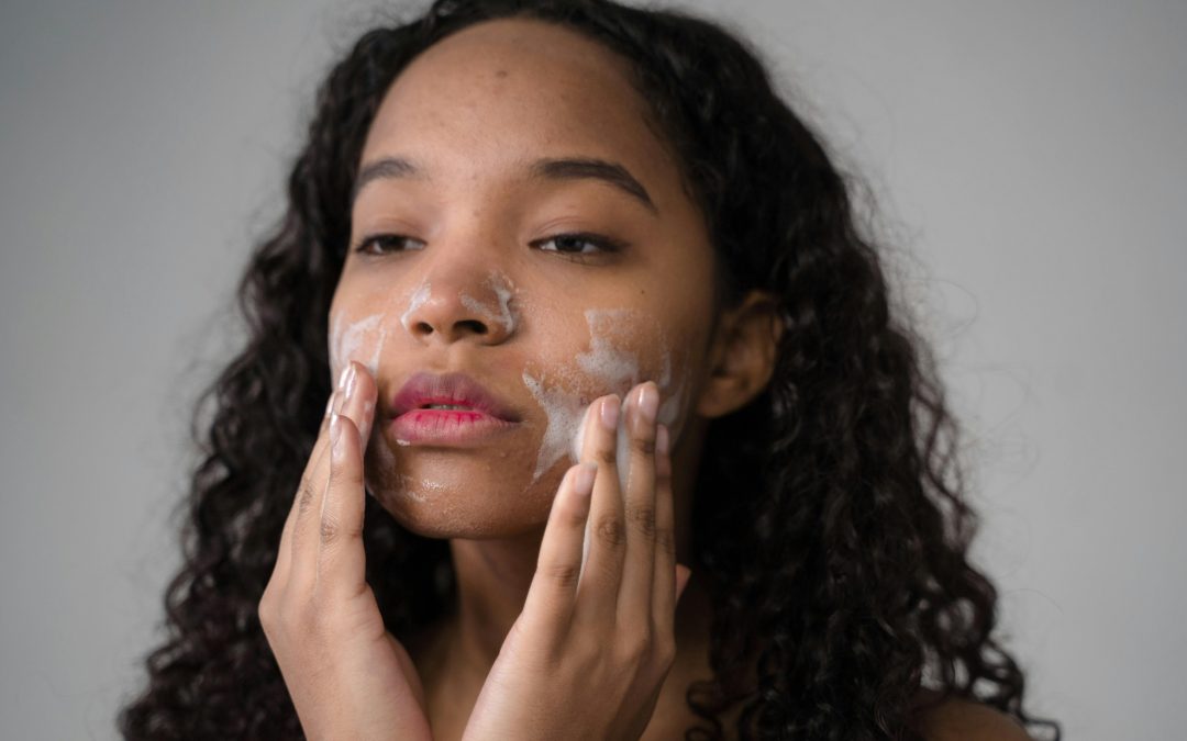 mixed race girl with long wavy hair washing her face